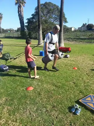 Adults and children at an outdoor Pesky Blubber workout — M218